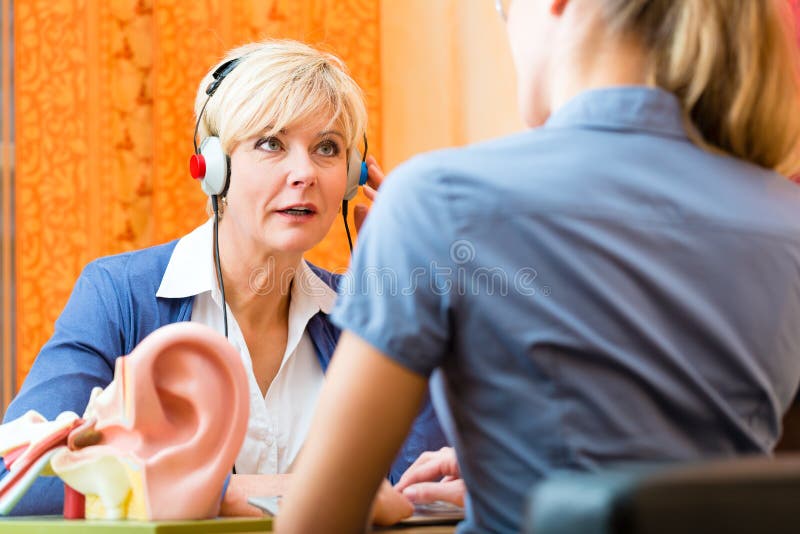 A mulher surda toma um teste de audição imagens de stock A mulher surda toma um teste de audição imagens de stock