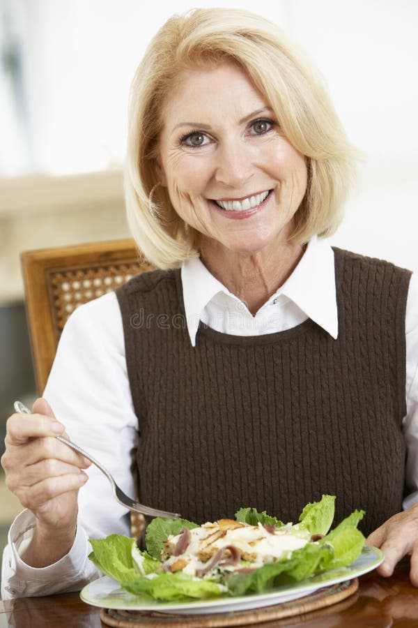 Mulher sênior que come a salada imagem de stock royalty free Mulher sênior que come a salada imagem de stock royalty free