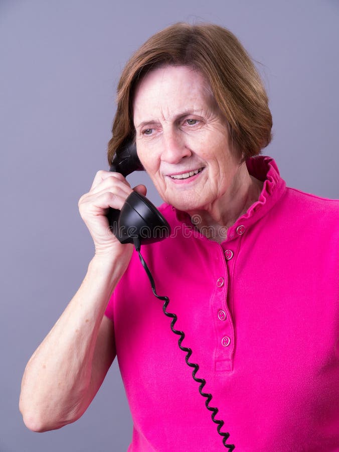 Mulher sênior que escuta no telefone fotos de stock royalty free Mulher sênior que escuta no telefone fotos de stock royalty free