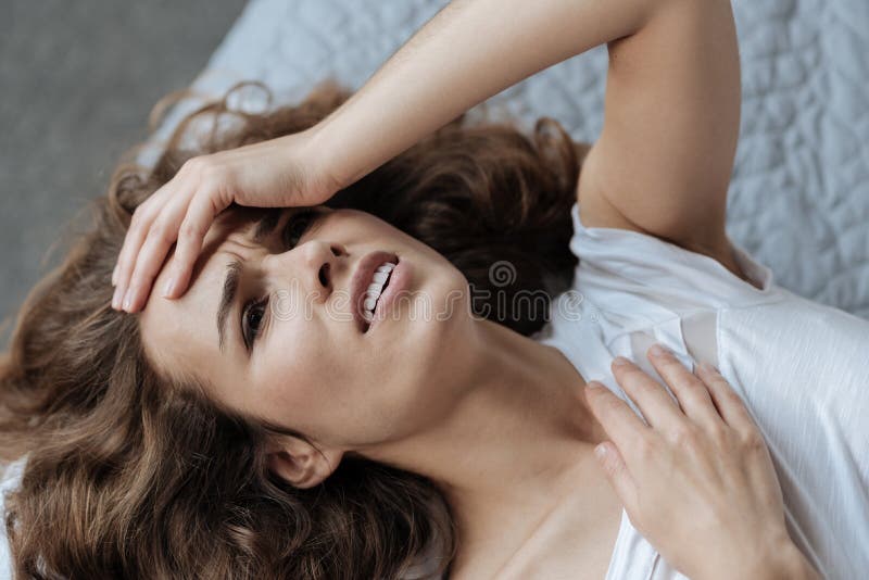 Mulher temperamental triste que tem uma dor de cabeça terrível fotos de stock Mulher temperamental triste que tem uma dor de cabeça terrível fotos de stock