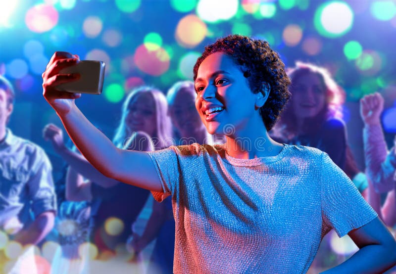 Festa, tecnologia, vida noturna e conceito de pessoas - amigos sorridentes  com smartphone tomando selfie no clube