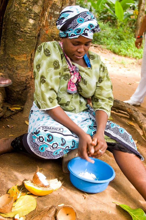 Zanzibar Tanzania 14/08/2010: Coconut processing,woman scrapes the coconut from the nut. Zanzibar Tanzania 14/08/2010: Coconut processing,woman scrapes the coconut from the nut