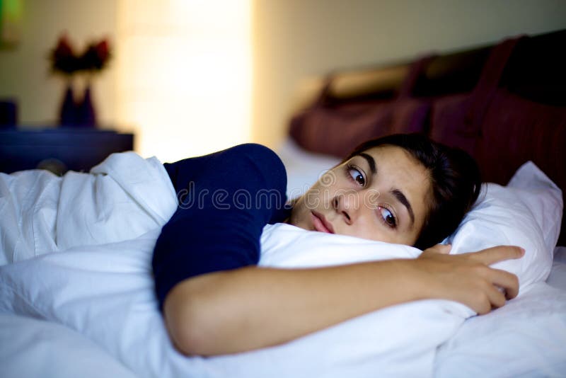 Mulher triste na cama que sente só fotografia de stock royalty free Mulher triste na cama que sente só fotografia de stock royalty free