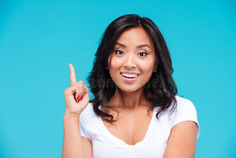 Mulher vietnamiana inspirada feliz que aponta acima e que tem uma ideia imagens de stock royalty free Mulher vietnamiana inspirada feliz que aponta acima e que tem uma ideia imagens de stock royalty free