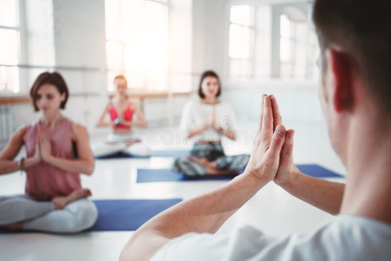 Mulheres adultas aptas e poses praticando da ioga do homem na classe da aptidão Grupo de povos fortes saudáveis que fazem exercíc foto de stock Mulheres adultas aptas e poses praticando da ioga do homem na classe da aptidão Grupo de povos fortes saudáveis que fazem exercíc foto de stock