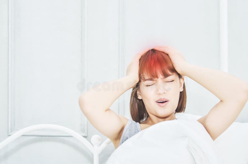 Mulheres asiáticas com uma dor de cabeça severa imagens de stock Mulheres asiáticas com uma dor de cabeça severa imagens de stock