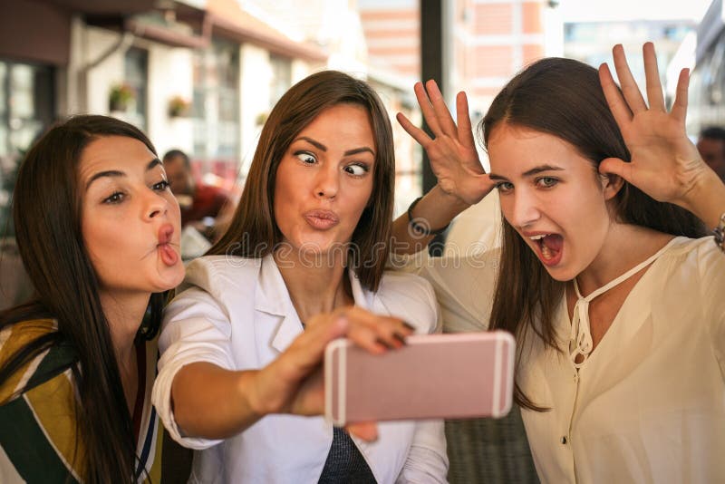 Mulheres de sorriso que tomam o selfie junto fora Meninas que fazem o funn fotos de stock royalty free Mulheres de sorriso que tomam o selfie junto fora Meninas que fazem o funn fotos de stock royalty free