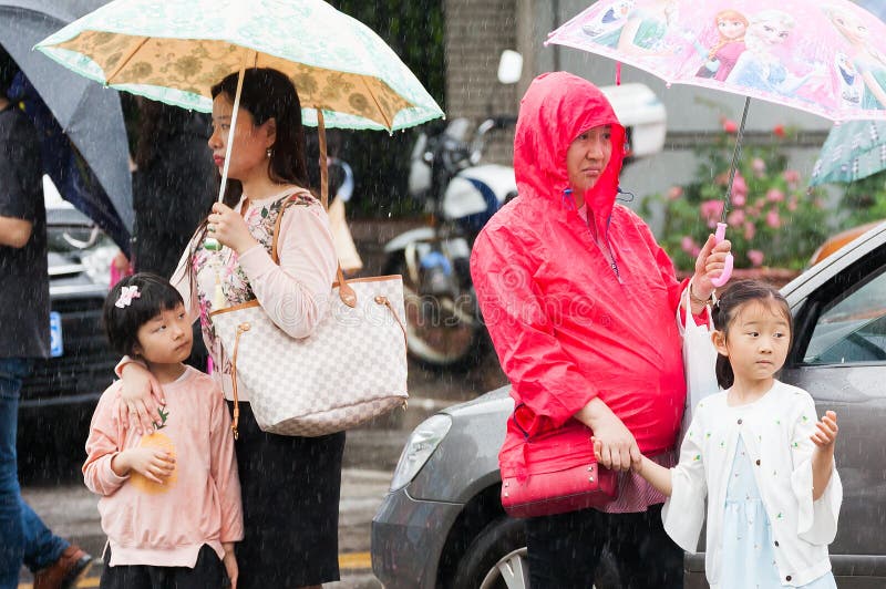 Mulheres e crianças que esperam um ônibus na chuva imagens de stock royalty free Mulheres e crianças que esperam um ônibus na chuva imagens de stock royalty free