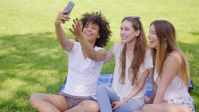 Mulheres felizes que tomam o selfie no parque