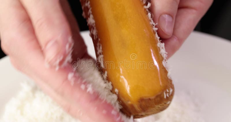 Mulheres mãos preparam um delicioso eclair com flocos de coco. video estoque