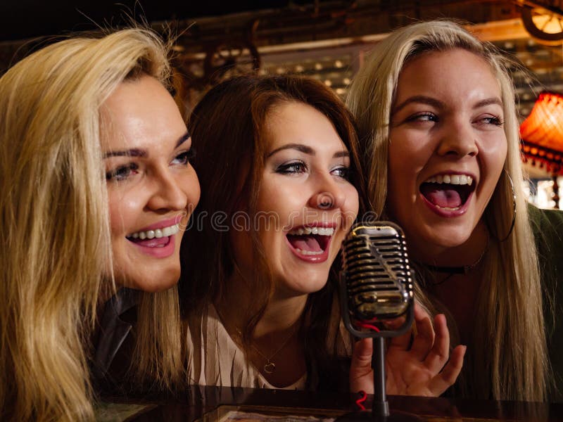 Mulheres que cantam com microfone imagens de stock Mulheres que cantam com microfone imagens de stock