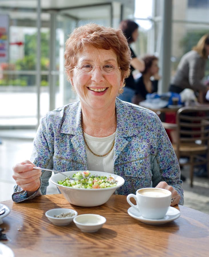 Mulheres sênior que comem a salada e o café fotografia de stock Mulheres sênior que comem a salada e o café fotografia de stock