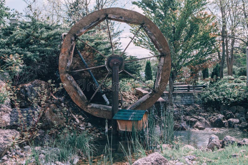 Mulino di legno della ruota dell'acqua vecchio nel villaggio del paese vicino alla corrente dello stagno fotografia stock libera da diritti Mulino di legno della ruota dell'acqua vecchio nel villaggio del paese vicino alla corrente dello stagno fotografia stock libera da diritti