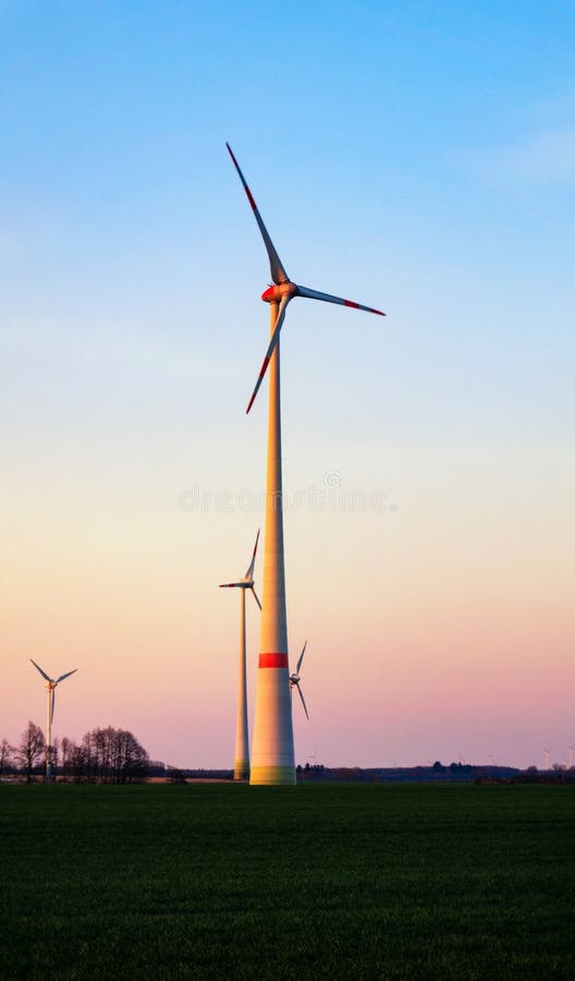 Mulino a vento al tramonto Azienda agricola delle turbine di vento fotografia stock libera da diritti Mulino a vento al tramonto Azienda agricola delle turbine di vento fotografia stock libera da diritti