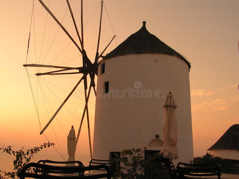 Mulino a vento al tramonto sull'isola di Santorini immagine stock Mulino a vento al tramonto sull'isola di Santorini immagine stock