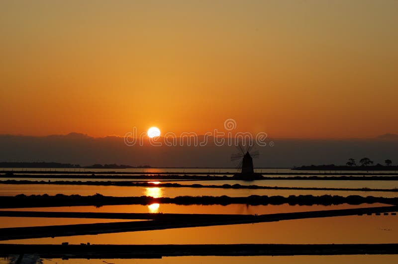 Mulino a vento in una salina siciliana fotografia stock