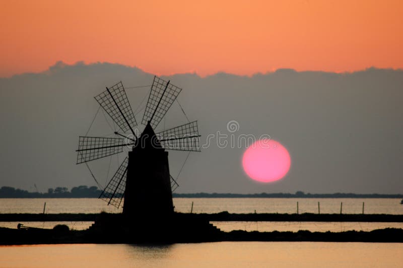 Mulino a vento in una salina siciliana fotografia stock