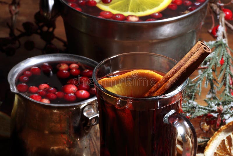 Mulled wine with cranberries, orange and cinnamon on a wooden table