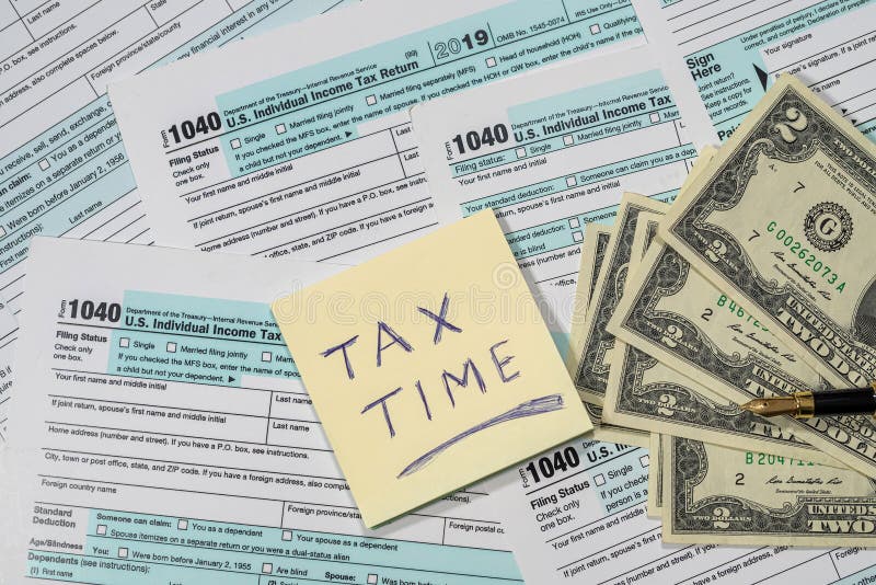Multe formulare de taxe americane 1040 sunt amestecate cu o bucată de hârtie dintr-un carnet pe ele. concept de documentare