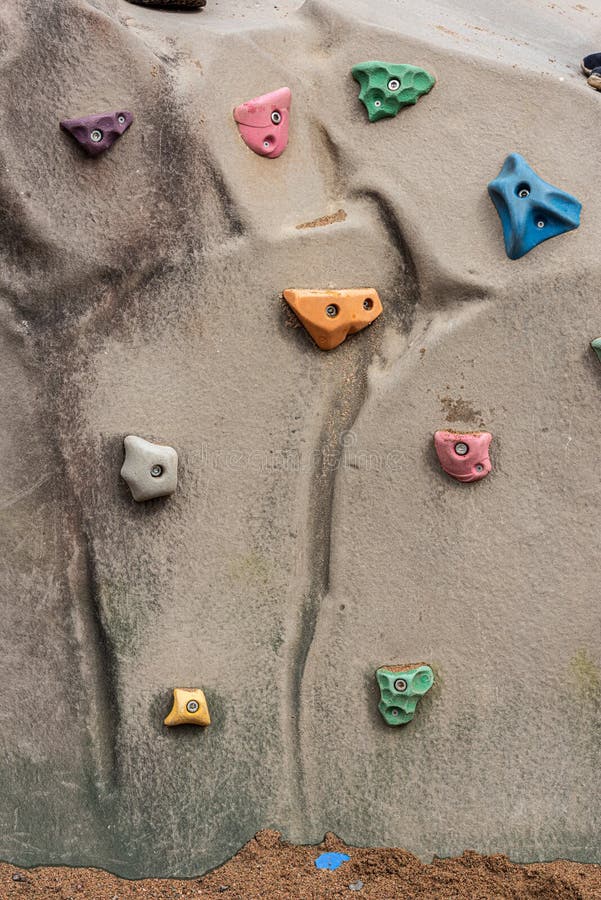 Multi colored climbing wall holds. Female climbing high risk building stock images, royalty-free photos and pictures