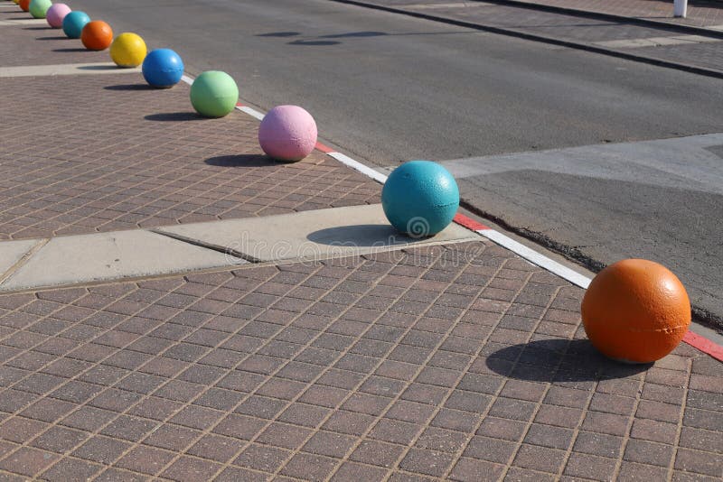 Multi-colored Concrete Balls Lie on the Sidewalk in the City Stock