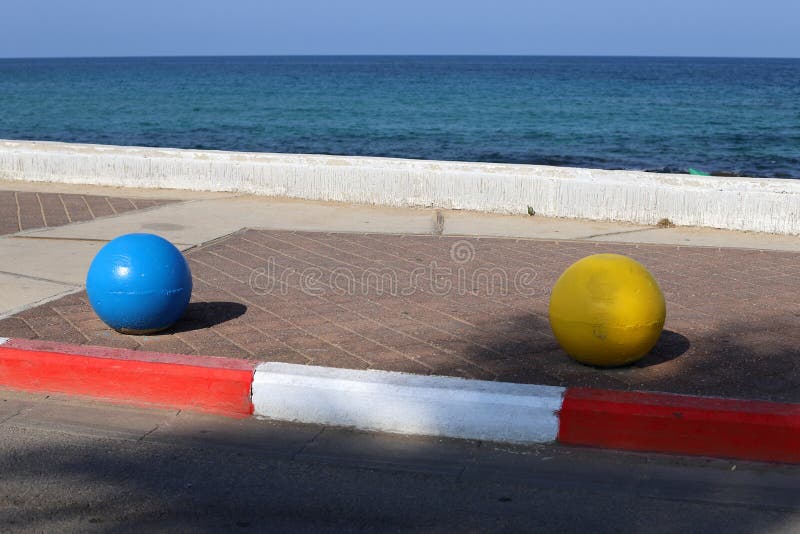 Multi-colored Concrete Balls Lie on the Sidewalk in the City Stock