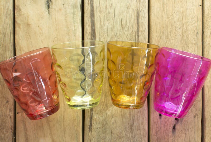 Multi-colored glazen water, dat op een houten tabl wordt geplaatst stock afbeeldingen Multi-colored glazen water, dat op een houten tabl wordt geplaatst stock afbeeldingen
