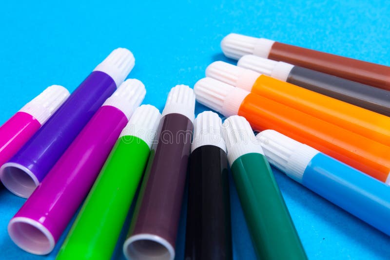Multi colored markers on blue background stock photo