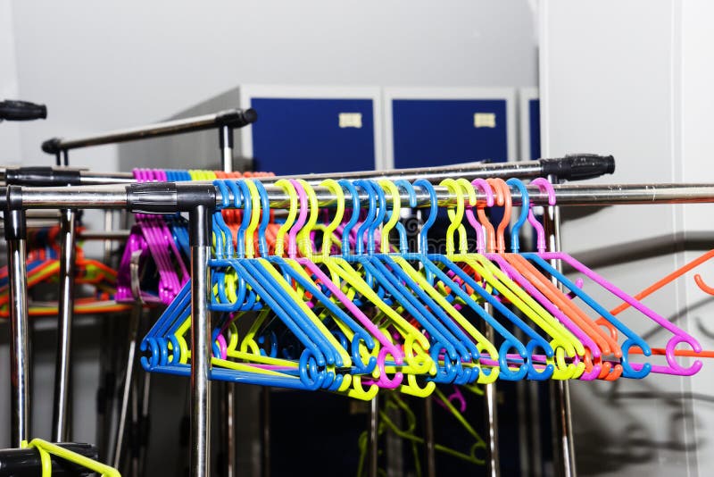 Multicolored Plastic Hangers Hanging on an Iron Rack Stock Photo