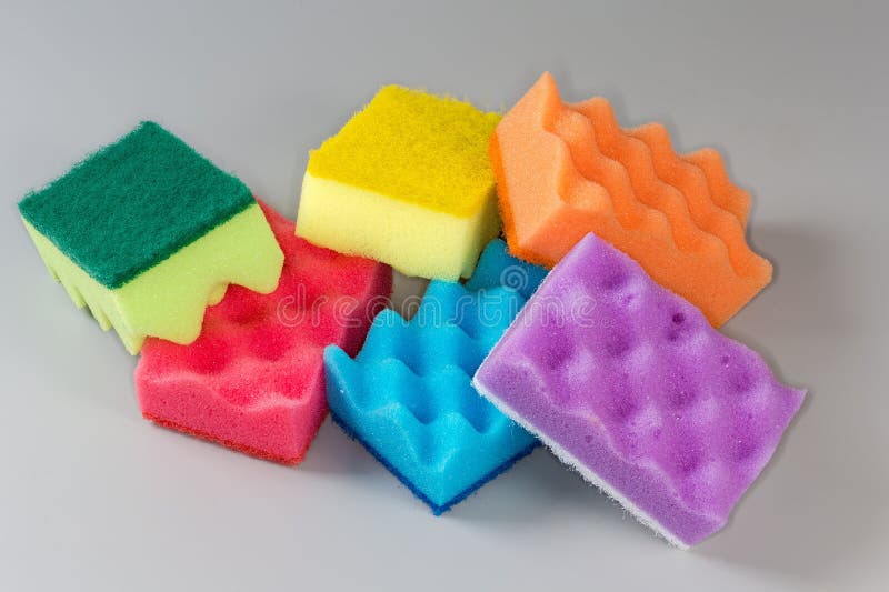 Several multi colored kitchen soft synthetic cleaning sponges with hard urethane abrasive layer on a gray background. Multi colored foam sponges stock images, royalty-free photos and pictures
