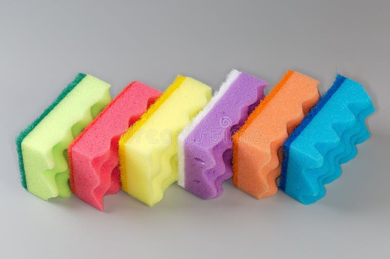Several multi colored kitchen soft synthetic cleaning sponges with hard urethane abrasive layer on a gray background. Multi colored foam sponges stock images, royalty-free photos and pictures