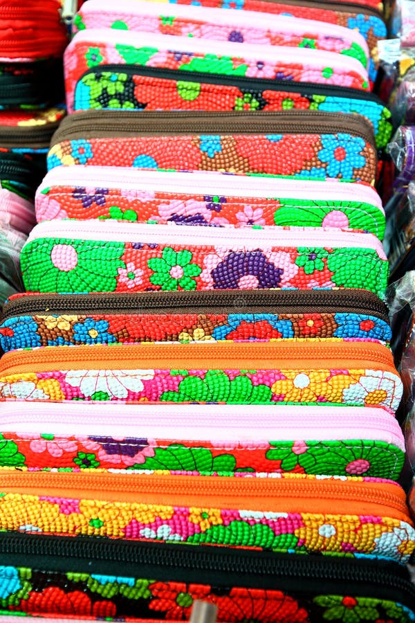 Multi coloured purse on sale at a asian open air street market .