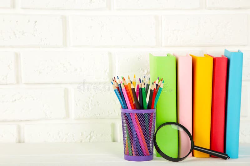 Multi Coloured School Books and Stationery on White Brick Wall