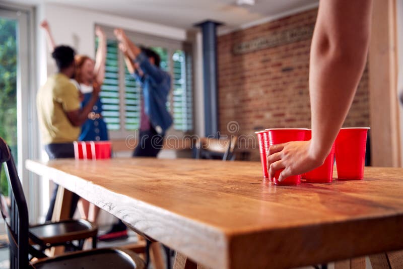 MultiCultural Group of Friends Playing Game at Home Together Throwing Ball into Plastic Cup