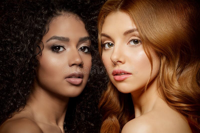 Multi-ethnic beauty. Caucasian and African. Different ethnicity women on black background. Beautiful vogue girls