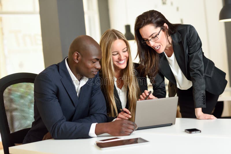 Multi-ethnic group of three businesspeople meeting in a modern o