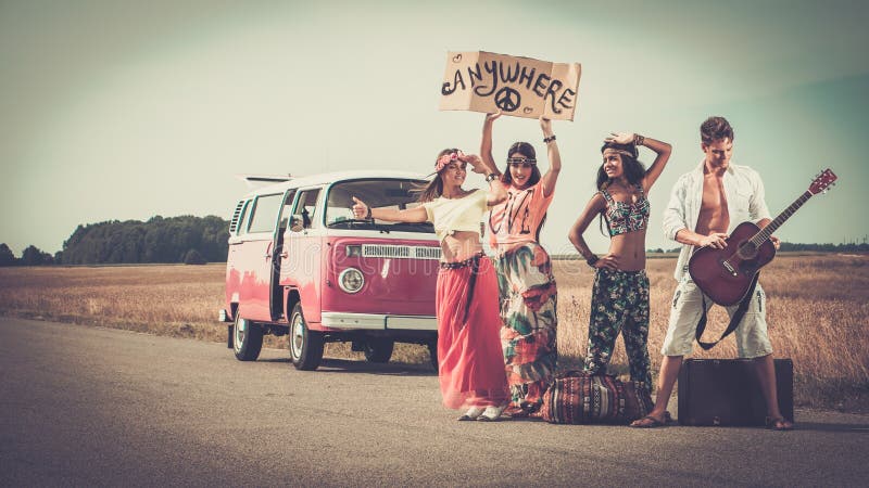 multi-ethnic-hippie-friends-road-trip-hitchhikers-guitar-luggage-43383714.jpg