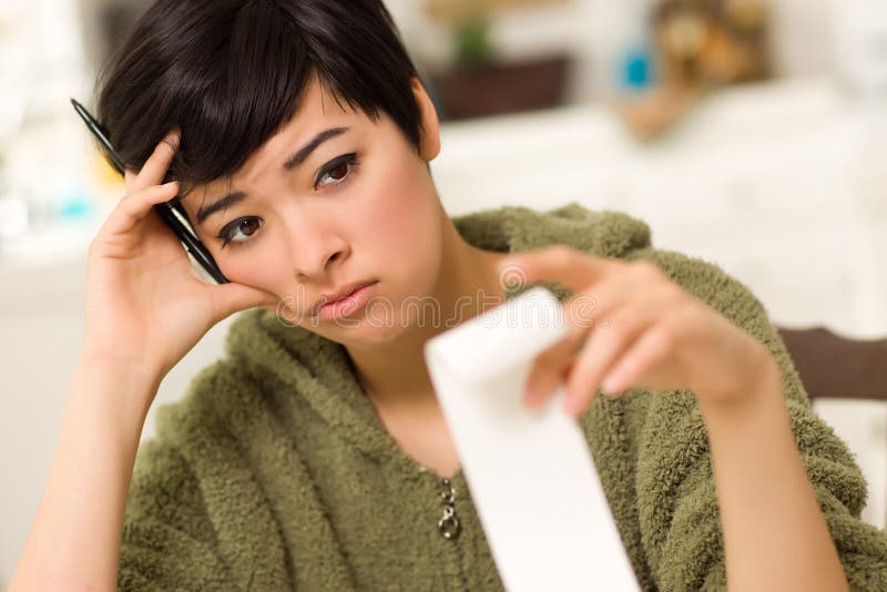 Multi-ethnic Young Woman Agonizing Over Financials royalty free stock photo Multi-ethnic Young Woman Agonizing Over Financials royalty free stock photo