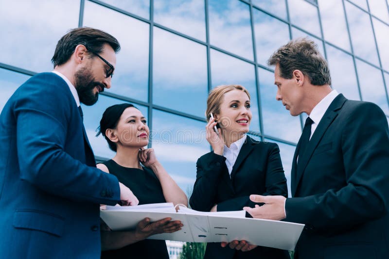 Multi-etnisch zakenlui die bespreking hebben dichtbij de moderne bureaubouw royalty-vrije stock afbeelding Multi-etnisch zakenlui die bespreking hebben dichtbij de moderne bureaubouw royalty-vrije stock afbeelding