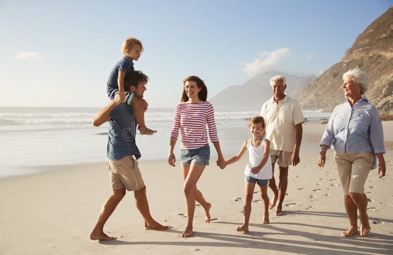 Multi família da geração em férias que anda ao longo da praia junto imagens de stock royalty free Multi família da geração em férias que anda ao longo da praia junto imagens de stock royalty free