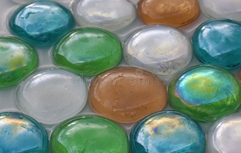 Multi gekleurde glasstenen die in water liggen royalty-vrije stock afbeelding Multi gekleurde glasstenen die in water liggen royalty-vrije stock afbeelding
