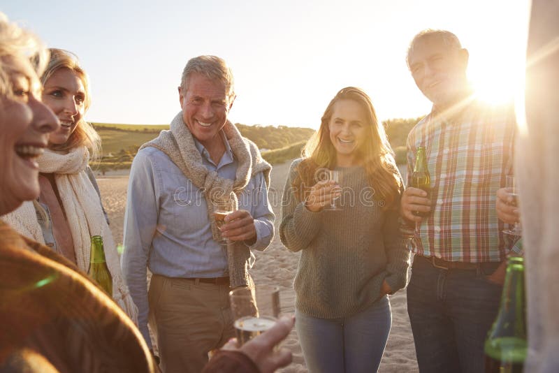 Multi-Generation Adult Family Celebrating With Wine On Winter Beach Vacation royalty free stock photos