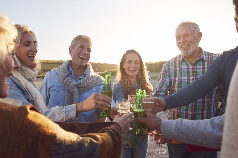 Multi-Generation Adult Family Making A Toast With Alcohol On Winter Beach Vacation stock photo
