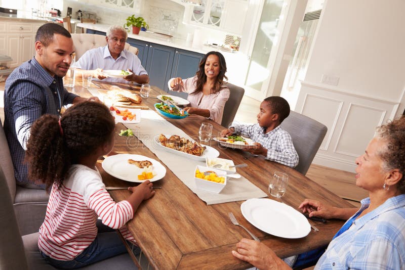 Multi Generation Black Family Serving a Meal in the Kitchen Stock Image