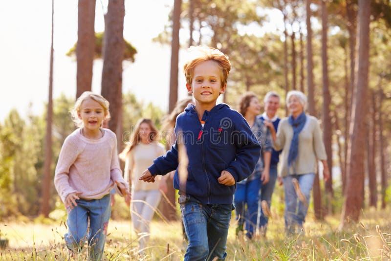Multi-generation family walking in countryside, kids running royalty free stock images Multi-generation family walking in countryside, kids running royalty free stock images