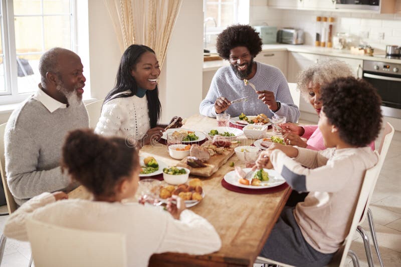 Multi generation mixed race family eating their Sunday dinner together at home, elevated view royalty free stock photography Multi generation mixed race family eating their Sunday dinner together at home, elevated view royalty free stock photography