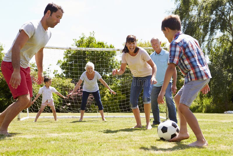 Multi Generation Playing Football In Garden Together stock photo Multi Generation Playing Football In Garden Together stock photo
