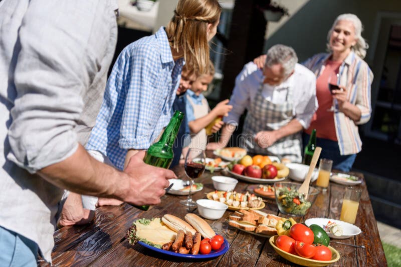 Multi-generational family having picnic on patio at daytime royalty free stock photography Multi-generational family having picnic on patio at daytime royalty free stock photography
