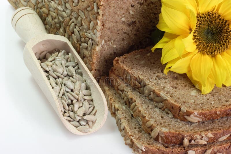 Multi-Grain-Bread with Sunflower Seeds. Sliced multigrain bread with sunflower seeds and sunflower blossom stock photos Multi-Grain-Bread with Sunflower Seeds. Sliced multigrain bread with sunflower seeds and sunflower blossom stock photos