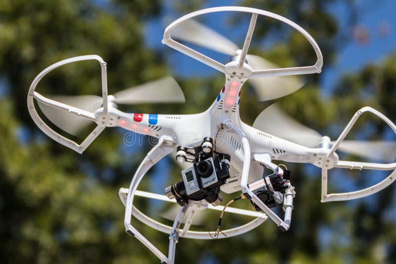 A small drone hovering with camera attached. A small drone hovering with camera attached